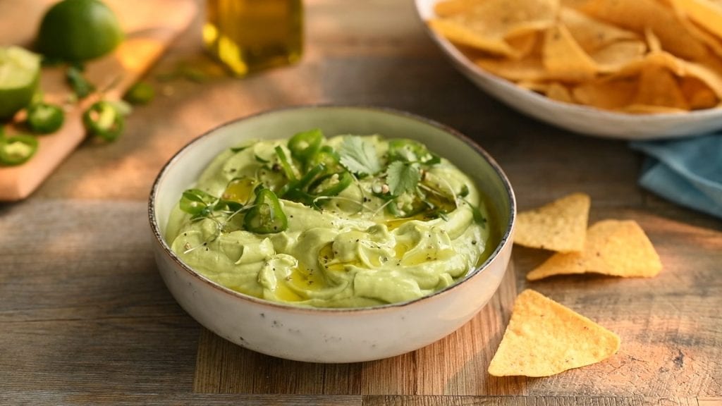 video of Nacho being dipped into an avocado dip.