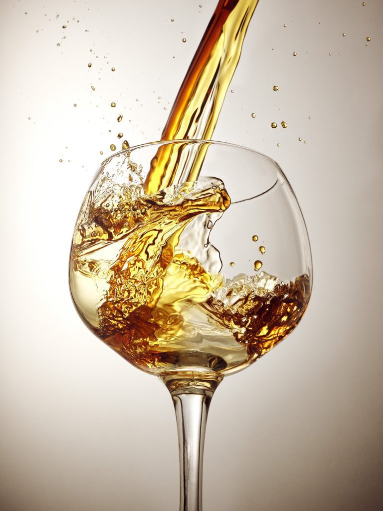 pimms pouring into a glass with splashes and drips